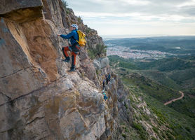 via ferrata, hombre escalando montaña con fondo de la Wall dúixo